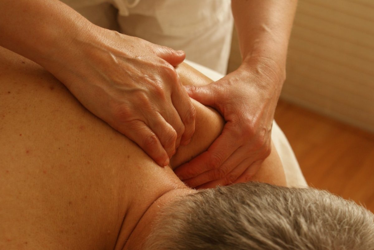 Mulher fazendo massagem em um homem.